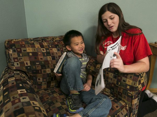 Mentor Alissa Rockwell, right, 13, 8th grade, reads with Tevin Vue, 6, kindergarten, at the Rolling Prairie Apartments in Sun Prairie in an after school program called the Homework Club March 17, 2015, in Sun Prairie. (Photo © Andy Manis)